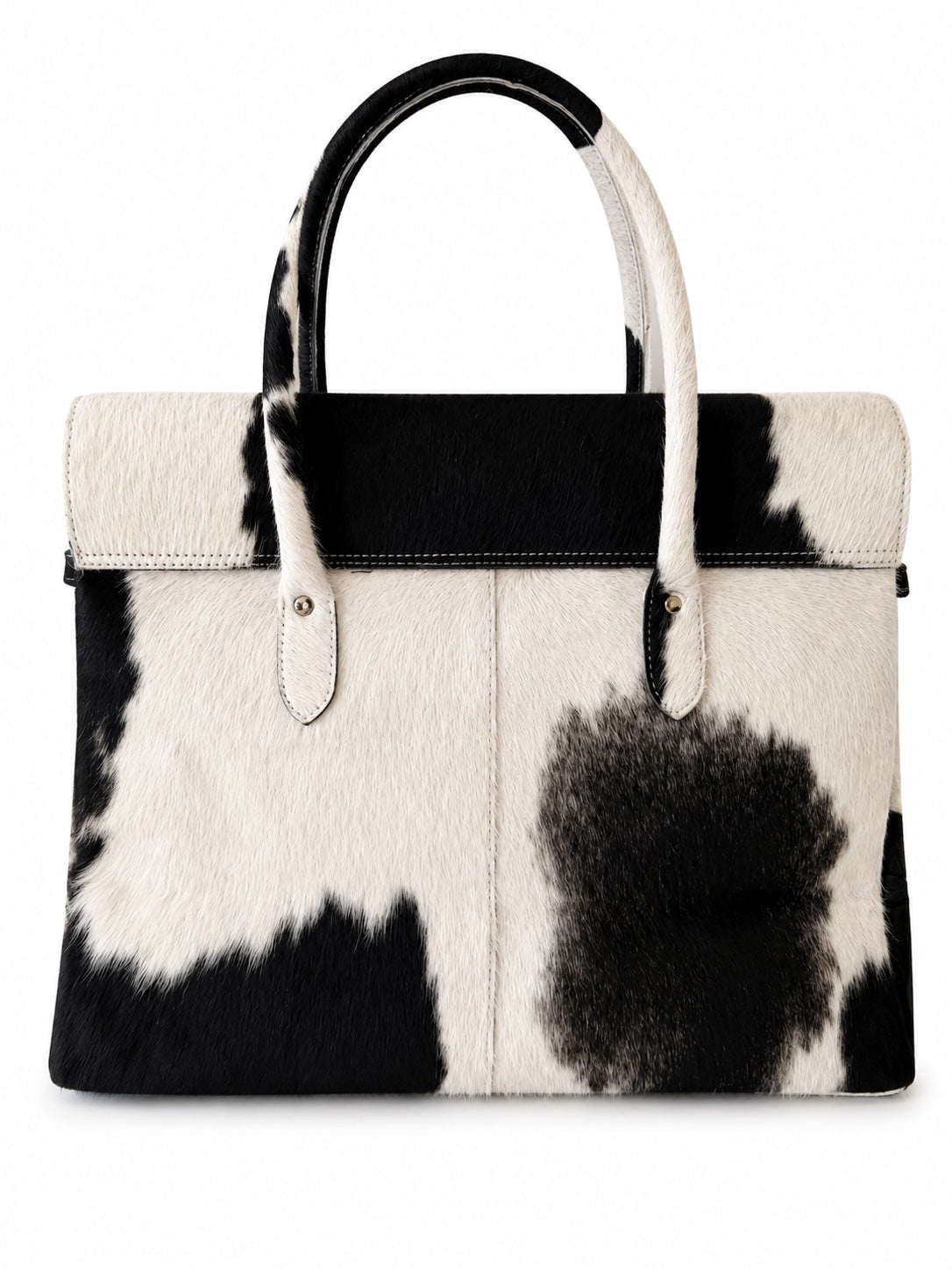 A structured handbag with a black and white cowhide pattern, featuring a black leather top handle, white leather trim, and a flap closure on a plain white background.