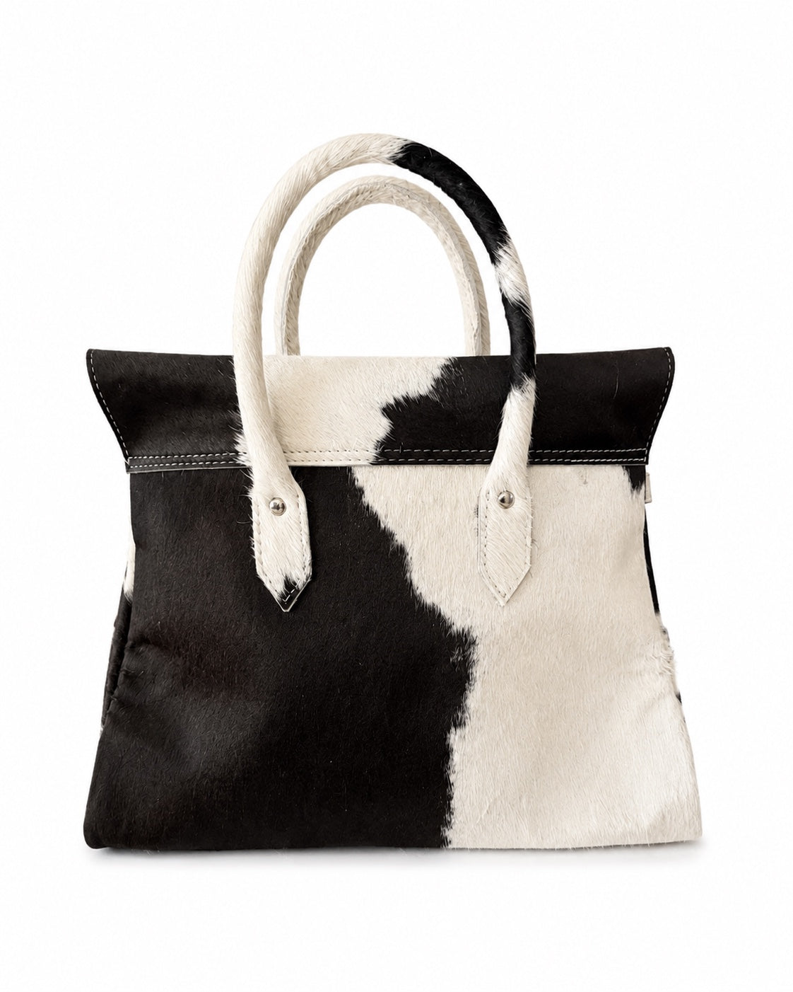 A structured cowhide handbag with a black and white pattern, featuring dual rolled top handles and silver-tone hardware, photographed against a plain white background.