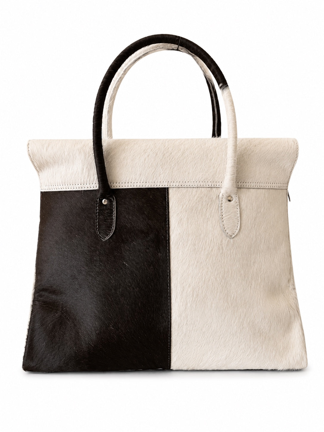A structured handbag made from two-tone animal hair or fur panels in black and off-white, featuring two curved top handles, photographed against a plain white background.