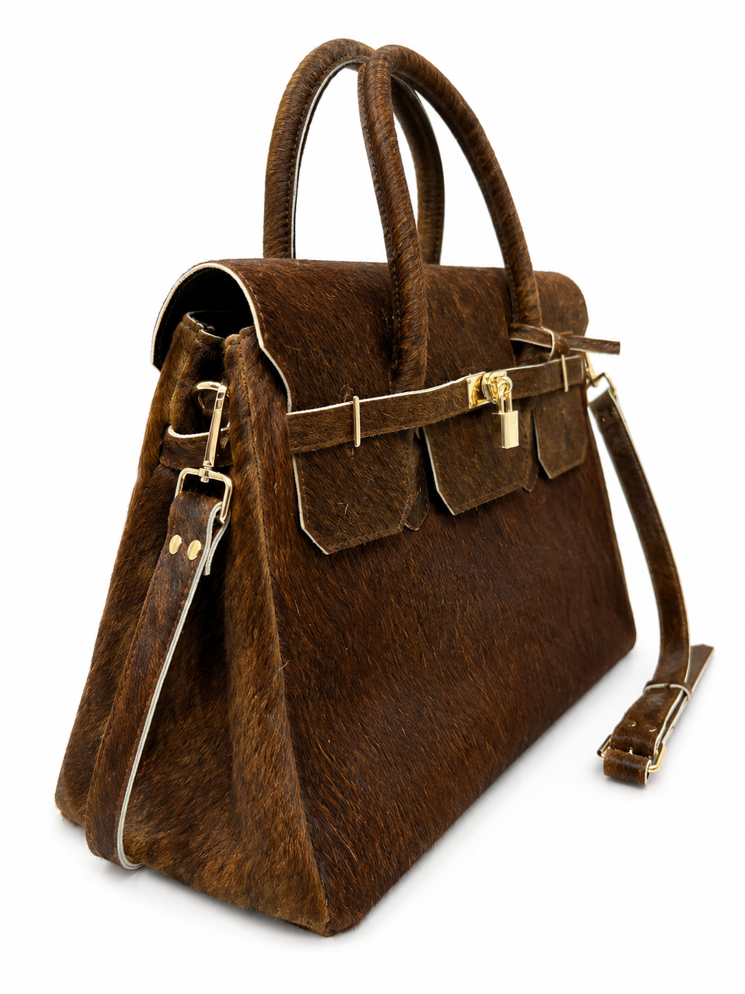 A structured brown handbag with a textured animal-print or hair-on-hide exterior, dual top handles, flap pockets with gold-tone hardware, and a detachable shoulder strap, shown on a plain white background.